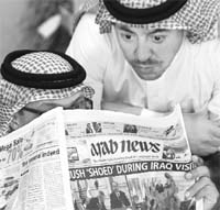 Saudi men read a newspaper with the headline Bush shoed during Iraq visit in Riyadh on Monday. 