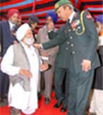 Major-General D.C. Katoch, chief of staff, Chetak Corps, listens to Bachittar Singh, who lost his legs in the war, during the Vijay Diwas celebrations in Bathinda cantonment