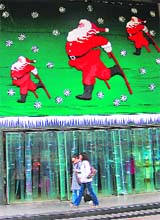 Shoppers walk by a department store decorated with Christmas decorations in Guiyang, southwest China Guizhou region, on Tuesday. China's economy could end 2008 with its weakest growth in nearly two decades, economists said, following the release of data for November that was far worse than expected.