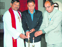 O.P. Uniyal and J.P. Uttarakhandi light candles at John Lang memorial service.