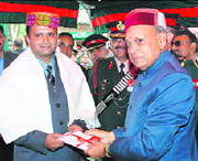 Chief minister Prem Kumar Dhumal presenting a draft of Rs 10 lakh to Shourya Chakra awardee Major Anshul Shukla on the occasion of Vijay Divas at Dharamsala on Tuesday.