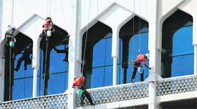 Workers paint as they abseil down a section of the damaged Taj Mahal hotel in Mumbai on Wednesday ahead of its December 21 reopening.