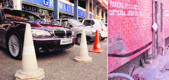 Roadblocks put up in front of Grewal Eye Institute to reserve the parking space; and right: “reserved parking” written on a wall in the backyard of the Chitkara office.