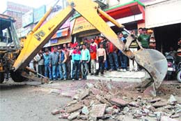 The municipal corporation authorities demolish encroacments on the link road opposite railway station in Amritsar on Friday. 