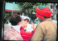 A spectator shows a match ticket purchased from the black marketer (with partially covered face) to a cop outside the PCA stadium on Friday.