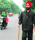 A lathi-wielding policeman patrols on roadside in Chandigarh on Friday.