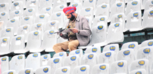 A policeman reads a newspaper in an empty stand at the PCA stadium in Mohali on Friday.