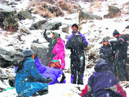 Tourists enjoy at Gulaba on the Manali-Leh highway, which experienced fresh spell of snow on Friday.