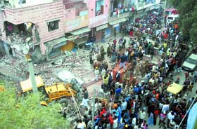 A mob gathers near the collapsed building at Jagatpuri in East Delhi
