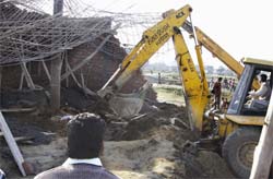A crane removes the debris of the under-construction house. 