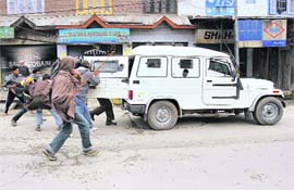 Agitators target a police vehicle during an anti-poll protest in Srinagar on Sunday.