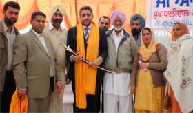 Sukh Dhaliwal, a Canadian MP (Centre), after receiving a sword and siropa from residents of village Bishnandi in Faridkot