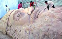 Artists from Orissa work on a 70-ft Santa Claus at the winter carnival in Sector 34, Chandigarh.