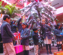 Children of Goodley Public School at Shalimar Bagh in New Delhi decorate the Christmas Tree on Monday.