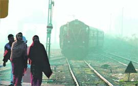 A train approaches Jammu railway station enveloped in thick fog on Monday. 