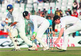 Gautam Gambhir (L) plays a shot as Matt Prior looks on during the fourth day of the second Test at the PCA Stadium at Mohali
