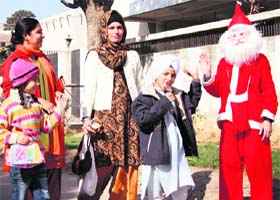 Santa Claus distributes gifts to children outside a school in Ludhiana
