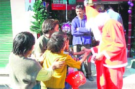 A man dressed as Father Xmas distributes sweets among poor children