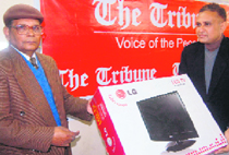 Col AK Chatterjee (retd) (L), winner of the first prize of "The Tribune Festival Bonanza Slogan Contest" receives an LCD TV from S.M.A. Kazmi, bureau chief of The Tribune, Dehradun, on Wednesday.