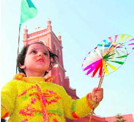 A child enjoys with a paper fan in front of a Catholic Church in Ambala