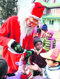 A Santa distributes sweets among children after the Christmas prayers at the Cathedral Church in Srinagar