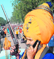 A Nihang Sikh speaks on his cellphone.