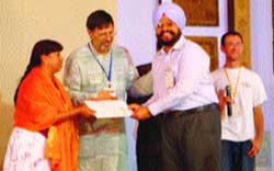 Anantdeep Singh being presented a scroll of honour by Charles Gibbs, executive director, URI, and Yoland Trevino, chairperson, Global Council, URI. 