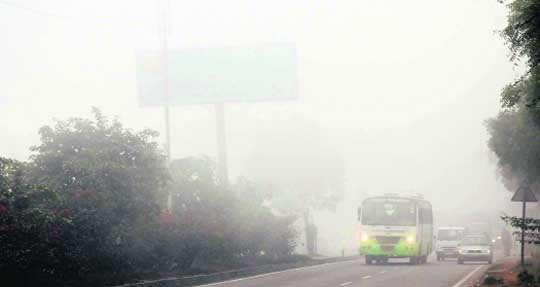 Vehicles move with their headlights on on the NH-1 in Karnal on a foggy Friday morning