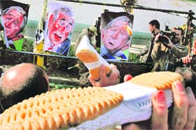SHOEING AWAY: Iranian men throw shoes at posters showing caricatures of US President George W. Bush prior to Friday prayers in Tehran