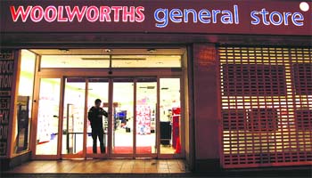 A worker locks the door on the last day of opening of a Woolworths store in Streatham in south London