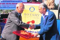 Rotarian Prem Bhalla hands over a memento to a partipant at the Rotary Club Central's charter nite in Dehradun.