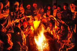Workers of various farmers organisations keep themselves warm at night on Monday near CCI office on Mal road.