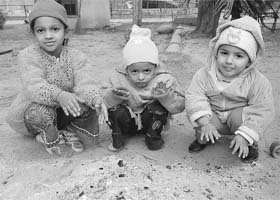 Children warm their hands on a chilly and foggy morning in Ambala