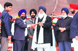MLA Gurtej Singh Ghuriana presents a sword to Chief Minister Parkash Singh Badal at Balluana village, near Abohar, on Tuesday. 