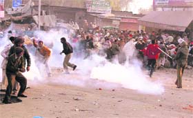 BSP supporters run for cover after the police fired teargas shells during a protest over the election results in Jammu