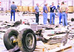 Members of the space shuttle Columbia reconstruction team examine pieces of debris from the spacecraft as it is assembled at the Kennedy Space Center in Cape Canaveral, Florida, in this May 7, 2003
