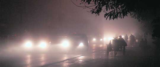 Motorists make their way through dense fog in Ludhiana