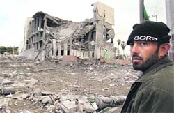 A man walks past the destroyed Palestinian Parliament building after an Israeli air strike in Gaza on Thursday. 