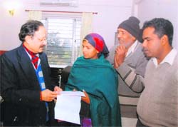 Uttarakhand CM Maj Gen BC Khanduri (retd) hands over a cheque for Rs 3 lakh to Babli in Dehradun on Friday. 