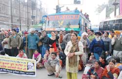 Lodging protest against the state government, activists of the Education Guarantee Scheme (EGS) Teachers Union blocking the main gate of the bus stand in Bathinda