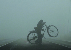 A cyclist crosses a railway track in blinding fog in New Delhi on Saturday.