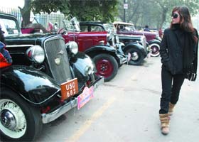 OLD BEAUTIES: A girl looks at the vintage cars on display at Khan Market as part of a vintage car rally 'Lutyens Delhi Drive'