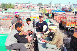 Truck drivers play cards in Jalandhar as the nationwide strike of truck operators unions continues on Monday.