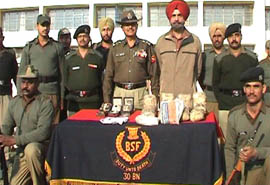 BSF officials with seized contraband at the Border Observation Post (BOP) SS Wala in Fazilka on Monday.