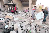 Palestinians collect their belongings from their destroyed house after an Israeli air strike in Gaza on Monday.  Reuters
