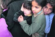 Palestinian kids wait in line to buy bread at a bakery in Gaza on Monday.