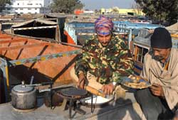 Truckers cook their meal atop their vehicle on a sunny winter afternoon as their strike continued