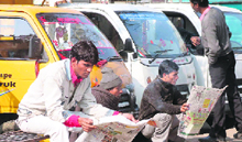 Truck drivers read newspapers in the old jail complex area in Gurgaon on the second day of their strike on Tuesday.
