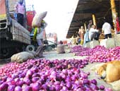 Labourers unload vegetables from trucks in a market in Jalandhar