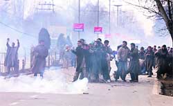 Muslim mourners are caught in tear smoke fired by cops during a Muharram procession in Srinagar 